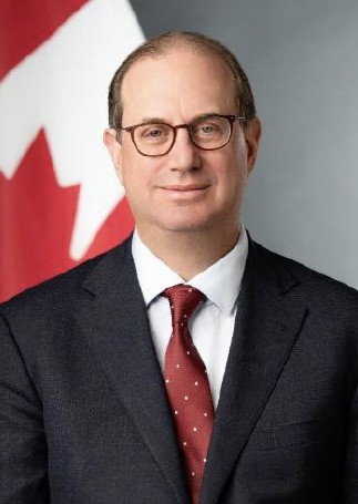 Headshot photo of Ambassador Mark Wiseman in front of a Canada flag